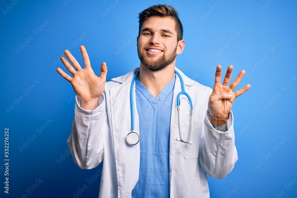Young blond doctor man with beard and blue eyes wearing white coat and stethoscope showing and pointing up with fingers number nine while smiling confident and happy. Young blond doctor man with beard and blue eyes wearing white coat and stethoscope showing and pointing up with fingers number nine while smiling confident and happy.