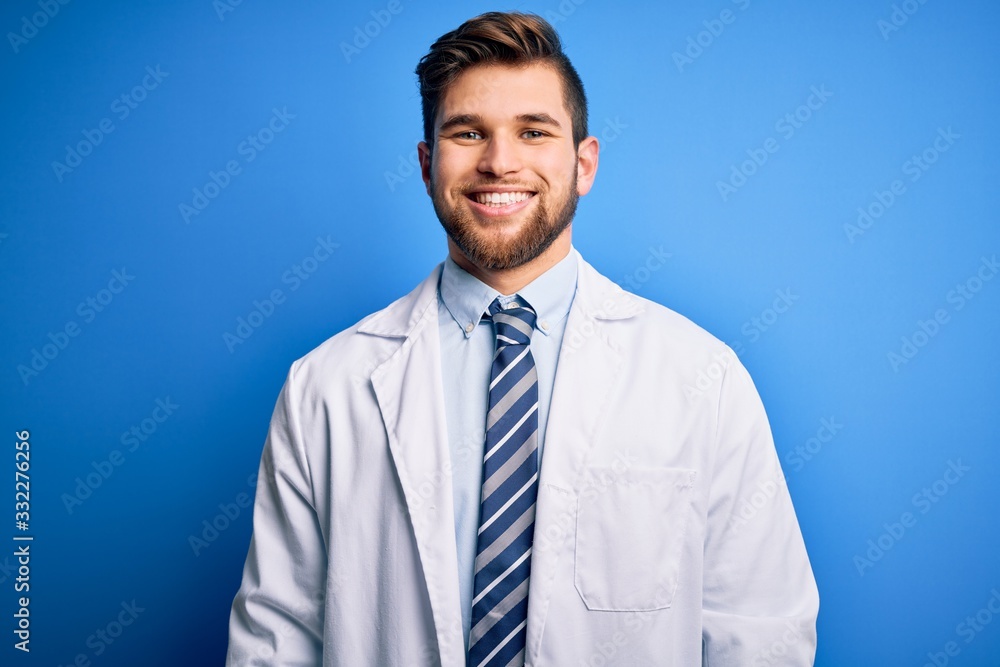 Young blond therapist man with beard and blue eyes wearing coat and tie over background with a happy and cool smile on face. Lucky person. Young blond therapist man with beard and blue eyes wearing coat and tie over background with a happy and cool smile on face. Lucky person.