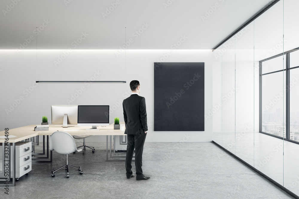 Businessman standing in office room with computers