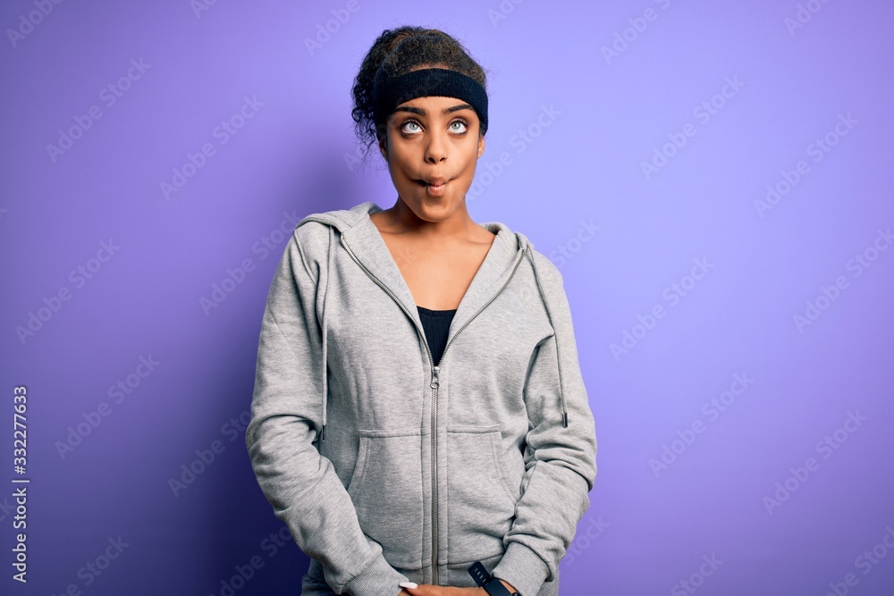 Young african american sportswoman doing sport wearing sportswear over purple background making fish face with lips, crazy and comical gesture. Funny expression. Young african american sportswoman doing sport wearing sportswear over purple background making fish face with lips, crazy and comical gesture. Funny expression.