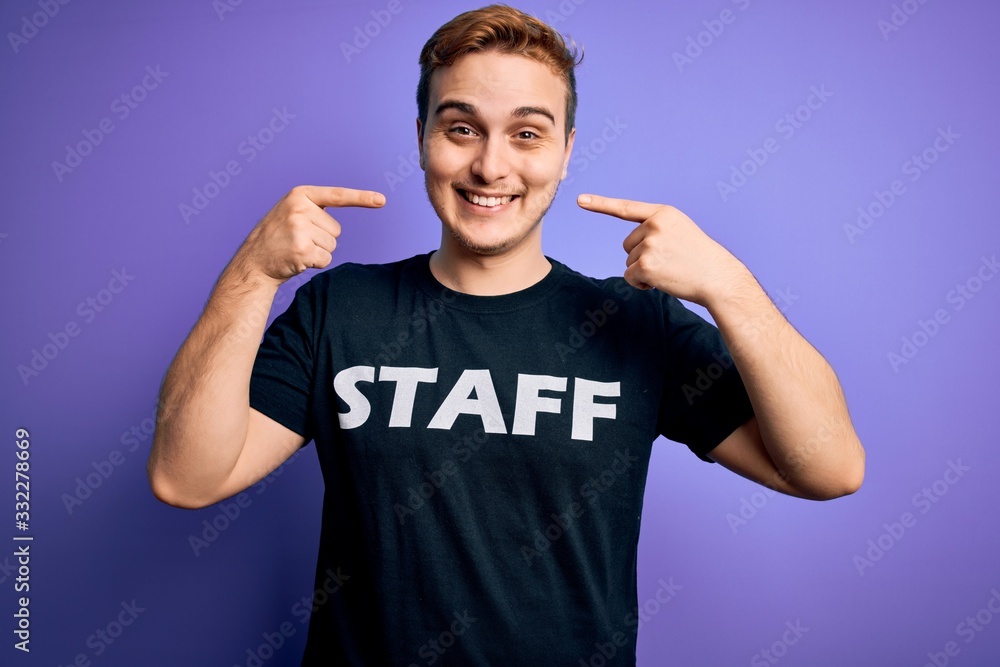 Young handsome redhead worker man wearing staff t-shirt uniform over purple background smiling cheerful showing and pointing with fingers teeth and mouth. Dental health concept. Young handsome redhead worker man wearing staff t-shirt uniform over purple background smiling cheerful showing and pointing with fingers teeth and mouth. Dental health concept.