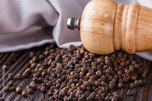 aromatic black pepper on a dark wooden rustic background