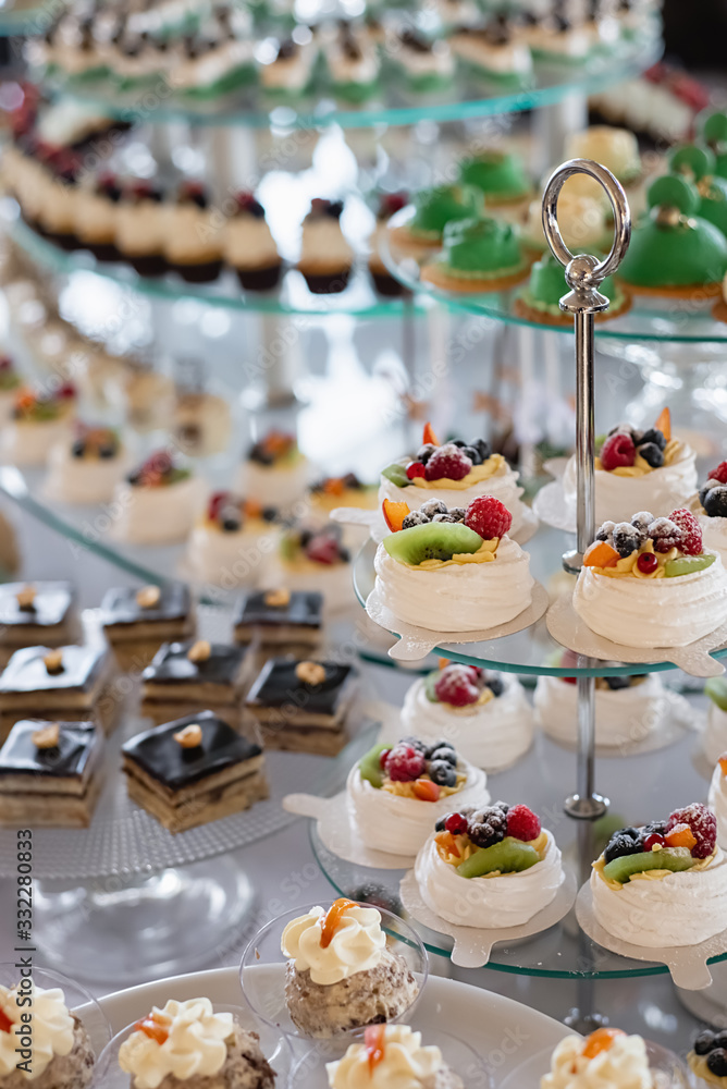 Details of a festival catering: cupcakes with fresh berries and cake pops, biscuits. Selective focus. Beautifully decorated table. Delicious candy bar at the wedding ceremony
