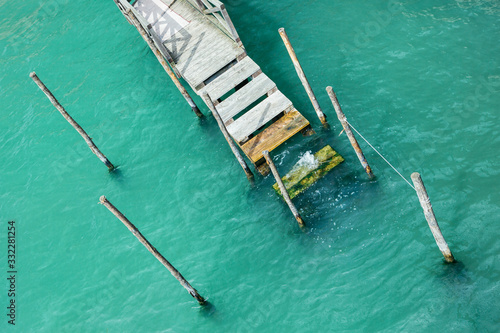 Wooden pier in Venice for boats. View from above. Against the background of azure water.
