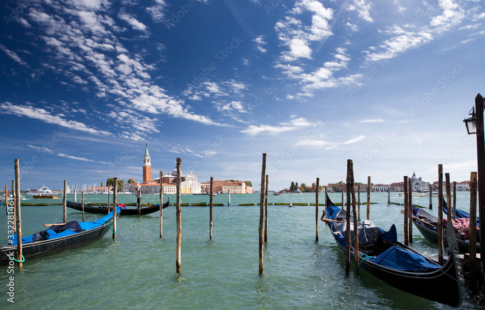 Gondolas are at the pier in Venice, overlooking the Church of San Giorgio Maggiore.