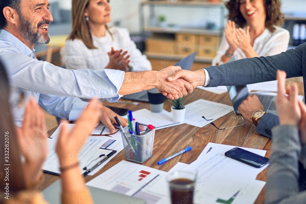 Group of business workers smiling happy and confident. Working together with smile on face shaking hands at the office Group of business workers smiling happy and confident. Working together with smile on face shaking hands at the office