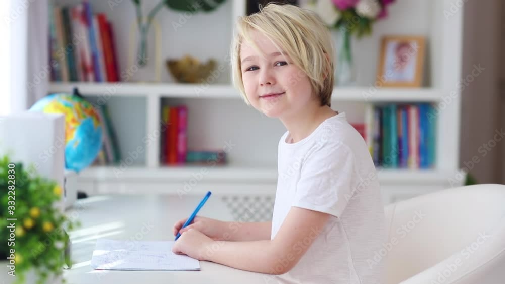 young boy, kid writing down notes at home, home schooling education young boy, kid writing down notes at home, home schooling education