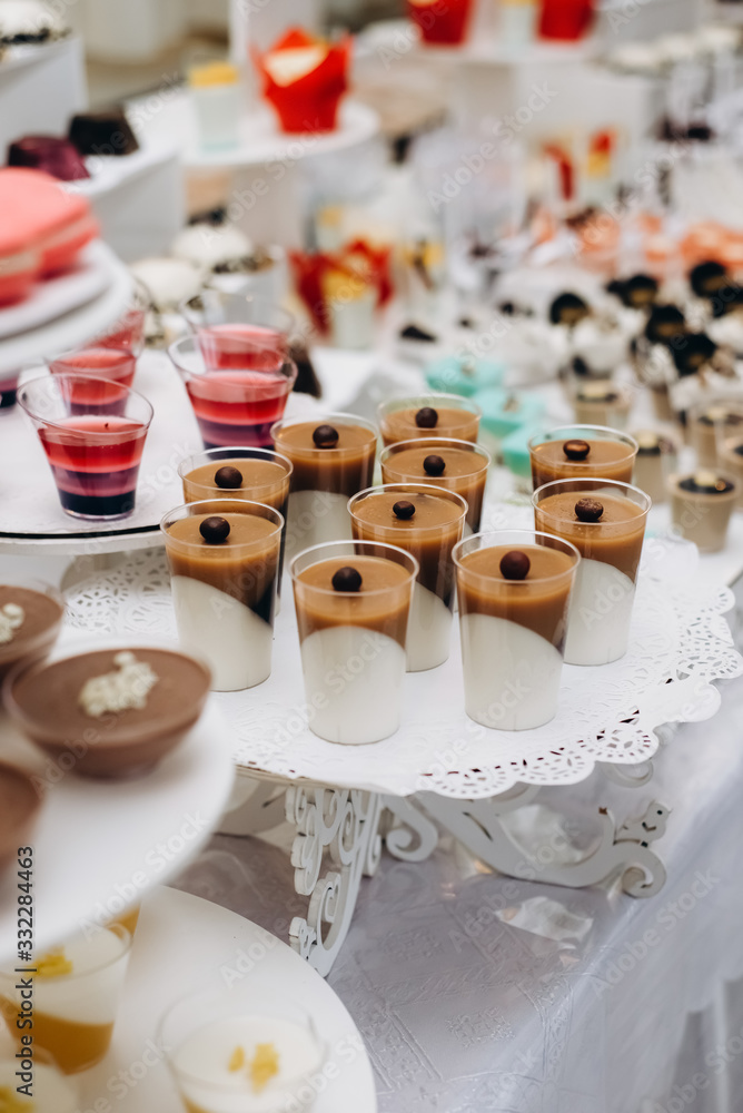 Close up of sweet table for wedding ceremony or birthday . Candy bar with a lot of different candies and sweet cakes. Selective focus. Party and holiday celebration concept