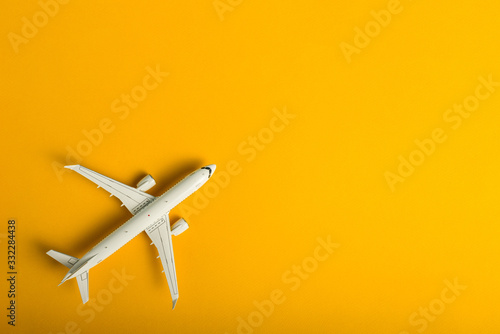 Travel concept. Top view of Jet airliner on yellow background with copy space. Online flight purchase, flight tickets booking