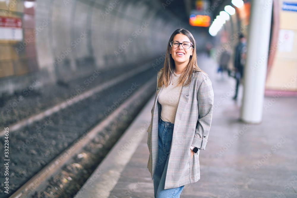 Young beautiful woman smiling happy and confident. Standing with smile on face at platform of train station Young beautiful woman smiling happy and confident. Standing with smile on face at platform of train station
