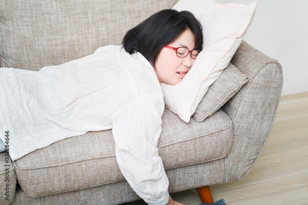 Fototapeta premium ソファーの上で寝る女性