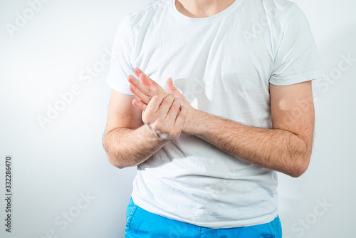 Hand pain. Medical and pharmaceutical concept. The man is holding his hand and feels severe pain.