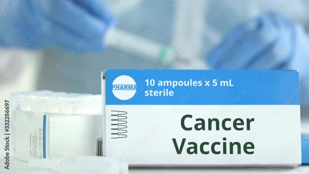 Box with cancer vaccine on the table against blurred lab assistant. Fictional phaceutical logo Box with cancer vaccine on the table against blurred lab assistant. Fictional phaceutical logo