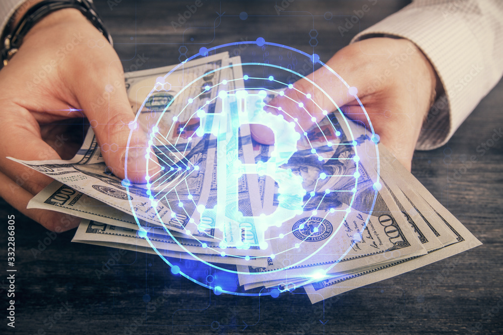 Multi exposure of blockchain theme drawing hologram and USA dollars bills and man hands. Business concept.