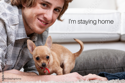 young men staying home with their puppy away from virus infectio photo