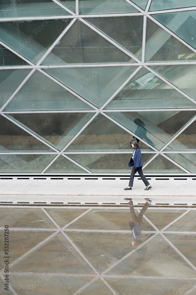 Young business women passing through glass buildings
