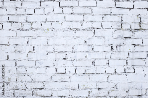 Old weathered aged brick wall colored in white. White brick wall background