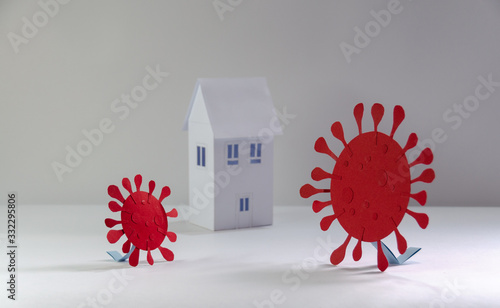 Representation of coronavirus COVID 19 made from paper trying to enter quarantined houses