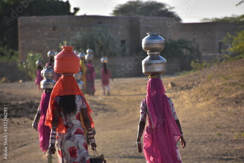 インドのラジャスタン州
ジャイサルメールのクーリー村
水瓶を頭に乗せて運ぶ、インド人女性
民族衣装のサリーを着て働く、美しい姿 photo