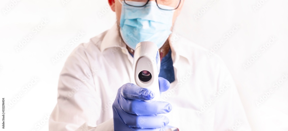 Doctor in gloves and face mask holding a infrared forehead thermometer, measuring body temperature. Corona. Coronavirus pandemic. Doctor in gloves and face mask holding a infrared forehead thermometer, measuring body temperature. Corona. Coronavirus pandemic.