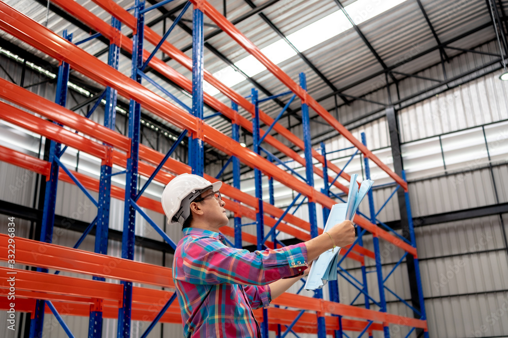 Engineer Man Worker Wearing Safety Helmet checking Interior of Distribution Warehouse.