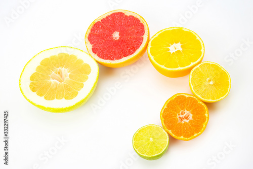 cut pieces of different citrus fruits on white background