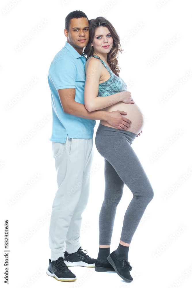 Handsome black man and his beautiful pregnant wife are hugging and smiling while. Isolated white background. Handsome black man and his beautiful pregnant wife are hugging and smiling while. Isolated white background.