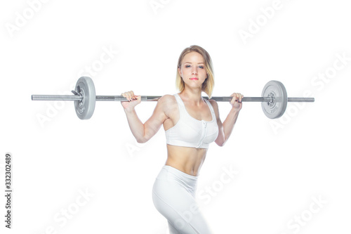 Beautiful athletic woman pumping up muscles with barbell on white background © satyrenko