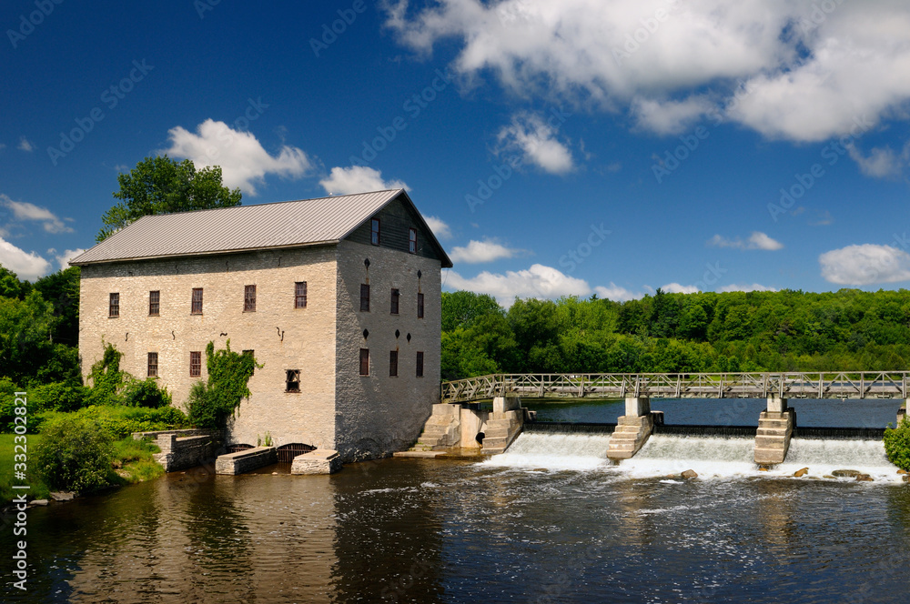 Lang Grist Mill and bridge over waterfall dam at Pioneer Village on the Indian River Ontario
