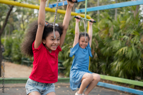 happy multi-ethnic children having fun to playing in the playground in summer time with smile and laughing healthy, funny smiling face adorable lovely female kid. happy vacation lifestyle concept.