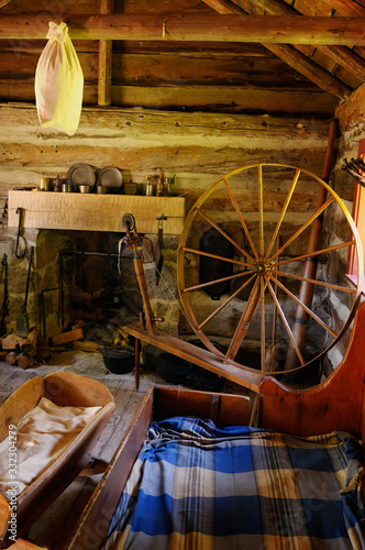 Primitive one room log cabin with beds and fireplace at Lang Pioneer Village photo