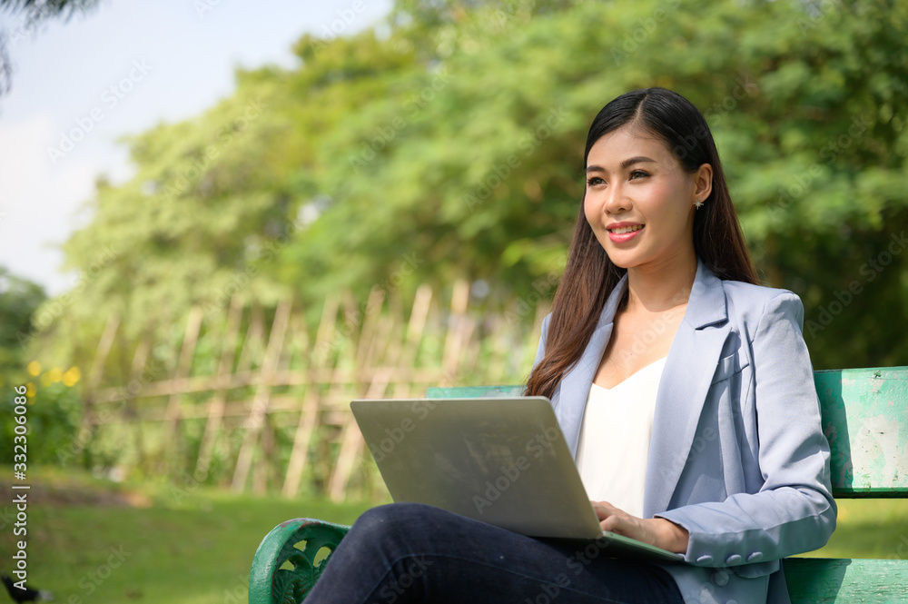 business women working online with laptop in the garden business women working online with laptop in the garden