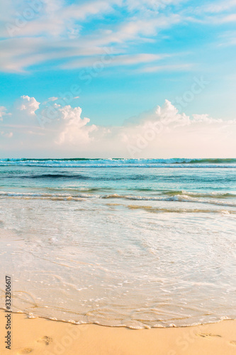Fototapeta Naklejka Na Ścianę i Meble -  Tropical sea shore. Cloudy sky and blue wavy ocean water. Sri Lanka.