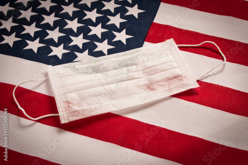 CORONAVIRUS. Protective medical mask on the background of the American flag . Concept of protection against coronavirus.