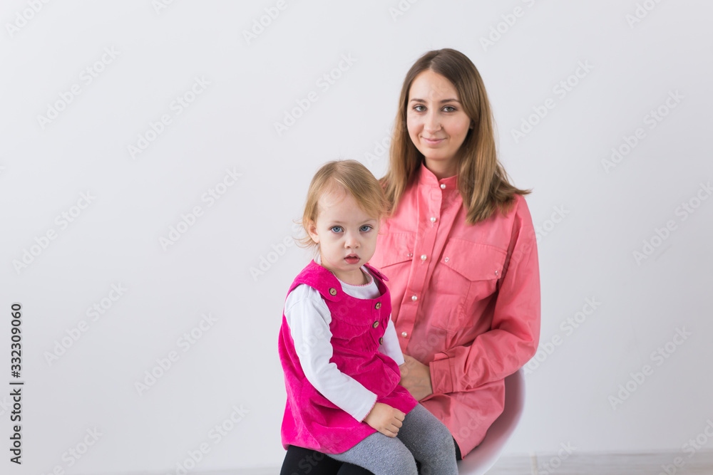 Childhood, love and family concept - Mother holds baby daughter on white background with copy space. Childhood, love and family concept - Mother holds baby daughter on white background with copy space.