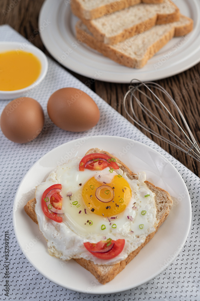 Bread placed with a fried egg with tomatoes, tapioca flour and sliced spring onions. Bread placed with a fried egg with tomatoes, tapioca flour and sliced spring onions.