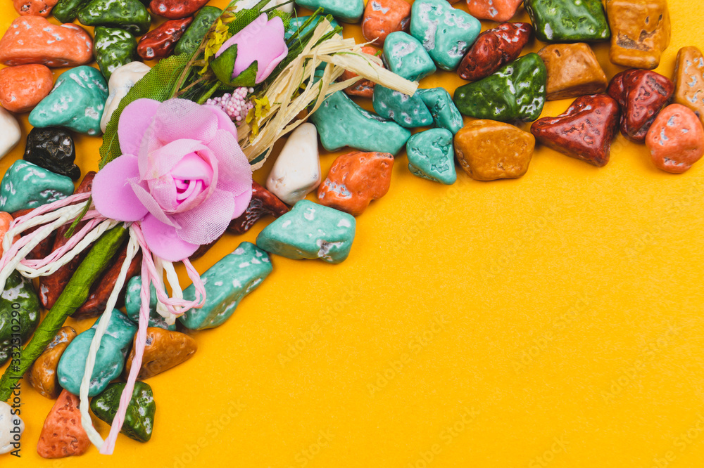 Festive decoration. candy pebbles. sweets in the form of colored stones on a yellow background