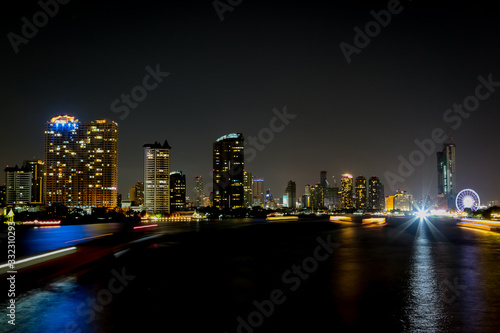 City at night with light bokeh and water reflection © pandaclub23