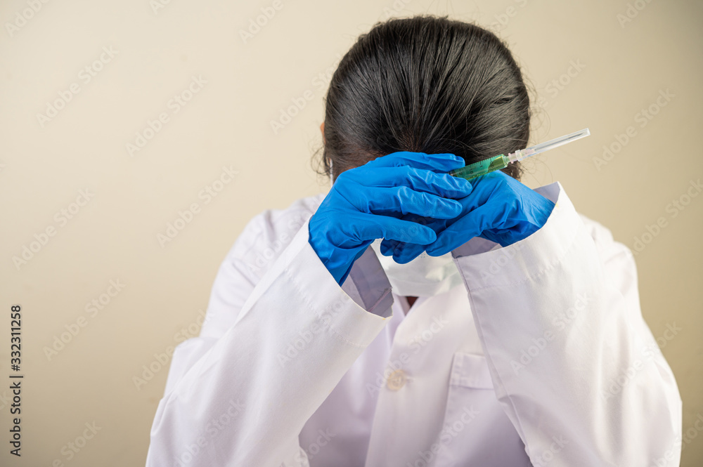 Naklejka premium Scientists wear gloves and hold syringes and then bend their heads.