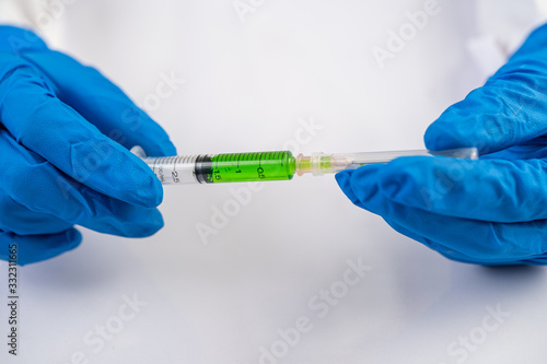 Scientists wearing masks and gloves Holding a syringe with a vaccine to prevent covic-19