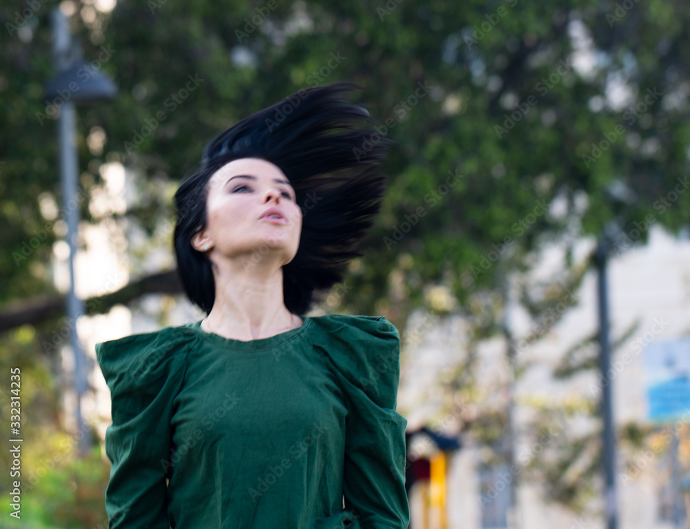 Beautiful girl enjoying nature outdoors in a park. The girl laughs and rejoices, a positive emotion. Beautiful girl enjoying nature outdoors in a park. The girl laughs and rejoices, a positive emotion.