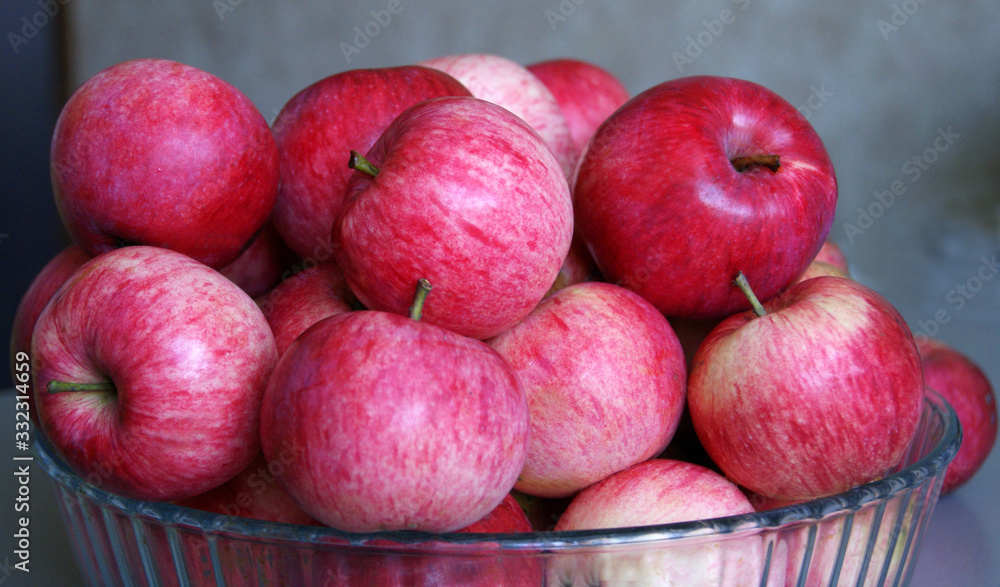 Fresh apples lie in a glass plate on a gray blurred background Fresh apples lie in a glass plate on a gray blurred background