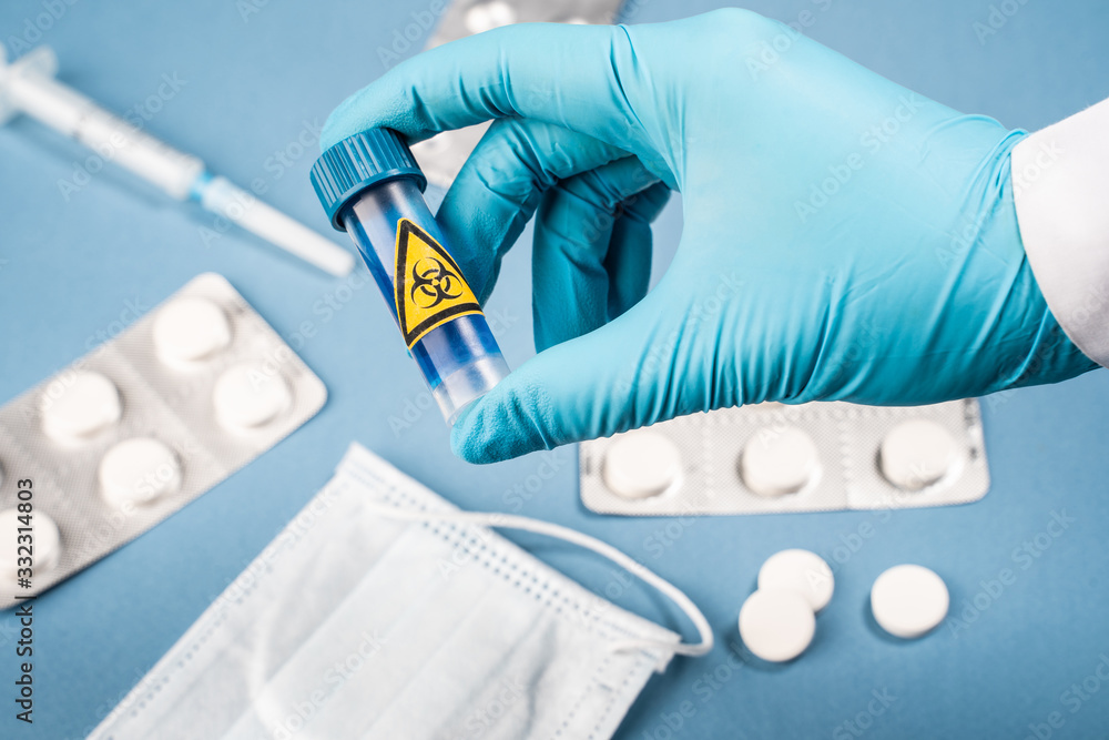A doctor in a protective suit holds a medicine against coronavirus. COVID-19 concept A doctor in a protective suit holds a medicine against coronavirus. COVID-19 concept
