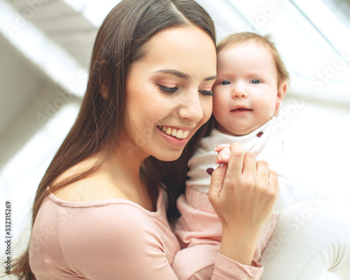 Beautiful woman with a baby is resting in a cozy house.