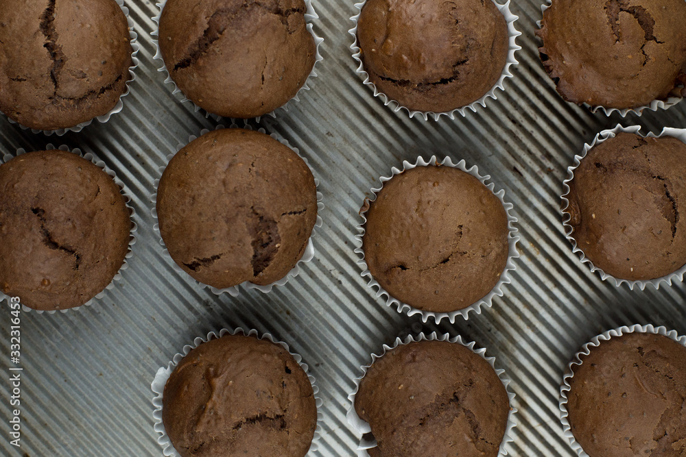 Top view simple chia seed chocolate muffins on a rustic baking sheet. Top view simple chia seed chocolate muffins on a rustic baking sheet.