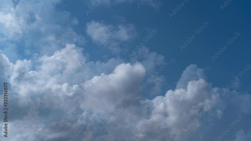 Seamless time lapse of white fluffy clouds that flow continuously in loop from left to right in the blue sky Seamless time lapse of white fluffy clouds that flow continuously in loop from left to right in the blue sky