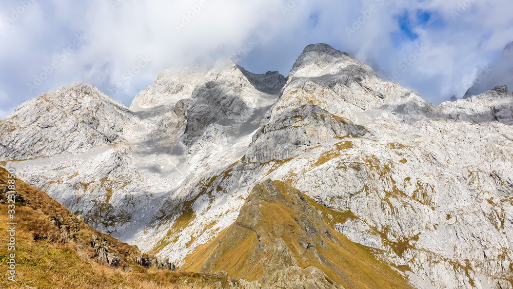 A golden colored mountains range at the Austrian-Italian border. The autumn vibes in Alps, nature getting ready for hibernation. Sharp, rocky Alpine peaks in the back. Serenity and solitude