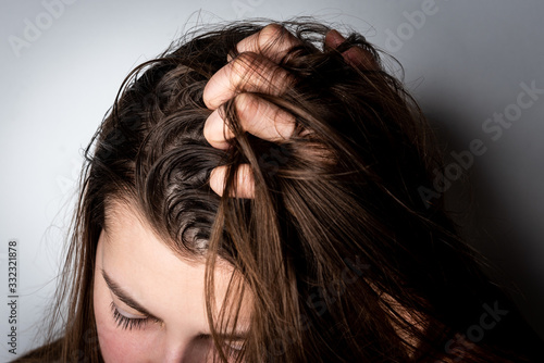 Konstfotografi Young woman with dirty greasy hair on gray background.