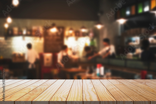 Empty wooden table with blurred restaurant kitchen background