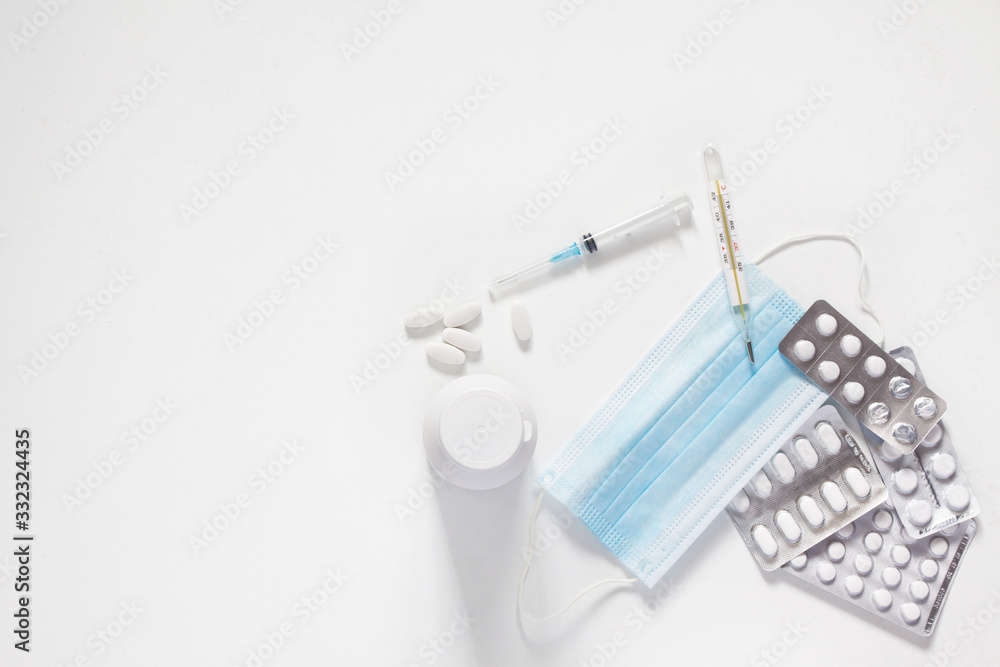 tablets and capsules for the treatment of colds and viral diseases. thermometer for measuring body temperature. a syringe for injection. the fight against viruses. white background. copy space tablets and capsules for the treatment of colds and viral diseases. thermometer for measuring body temperature. a syringe for injection. the fight against viruses. white background. copy space